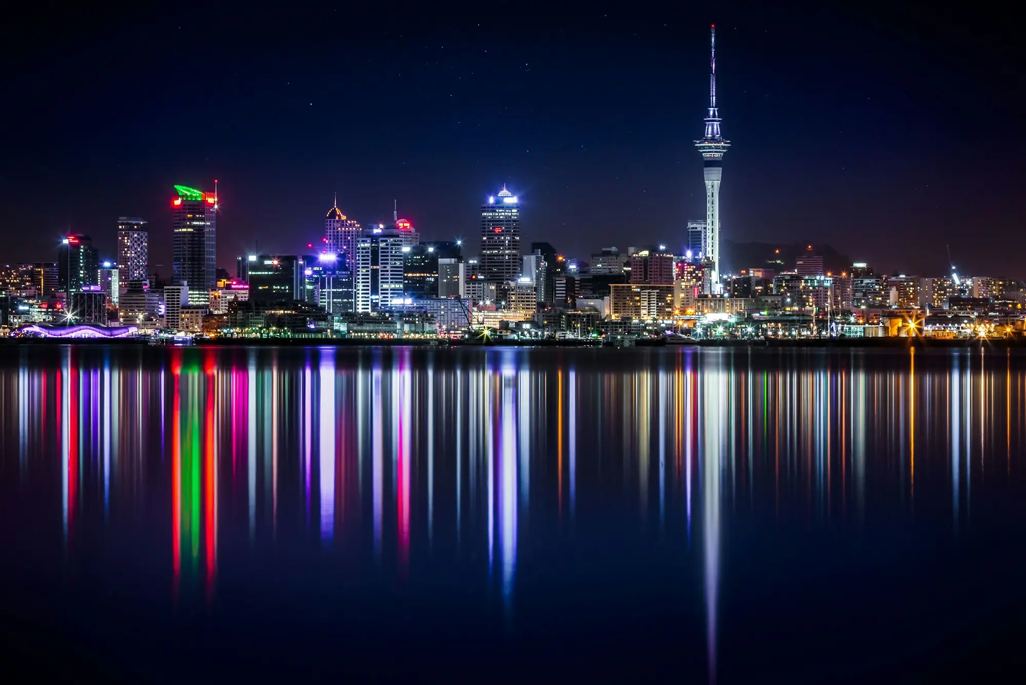 Auckland waterfront buildings lit up at night beside the harbour
