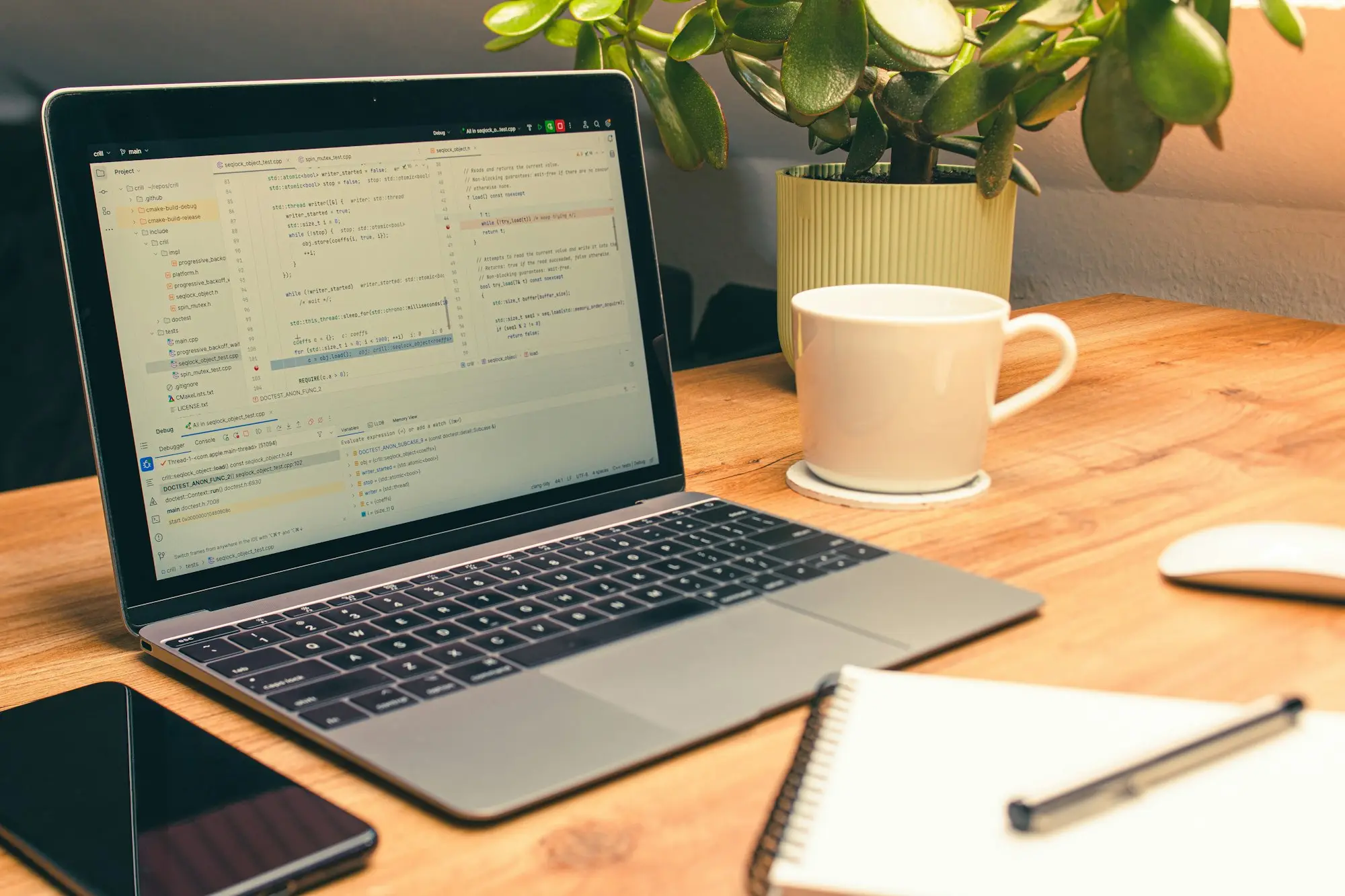 Laptop, coffee mug and plant on a desk set up for paperwork