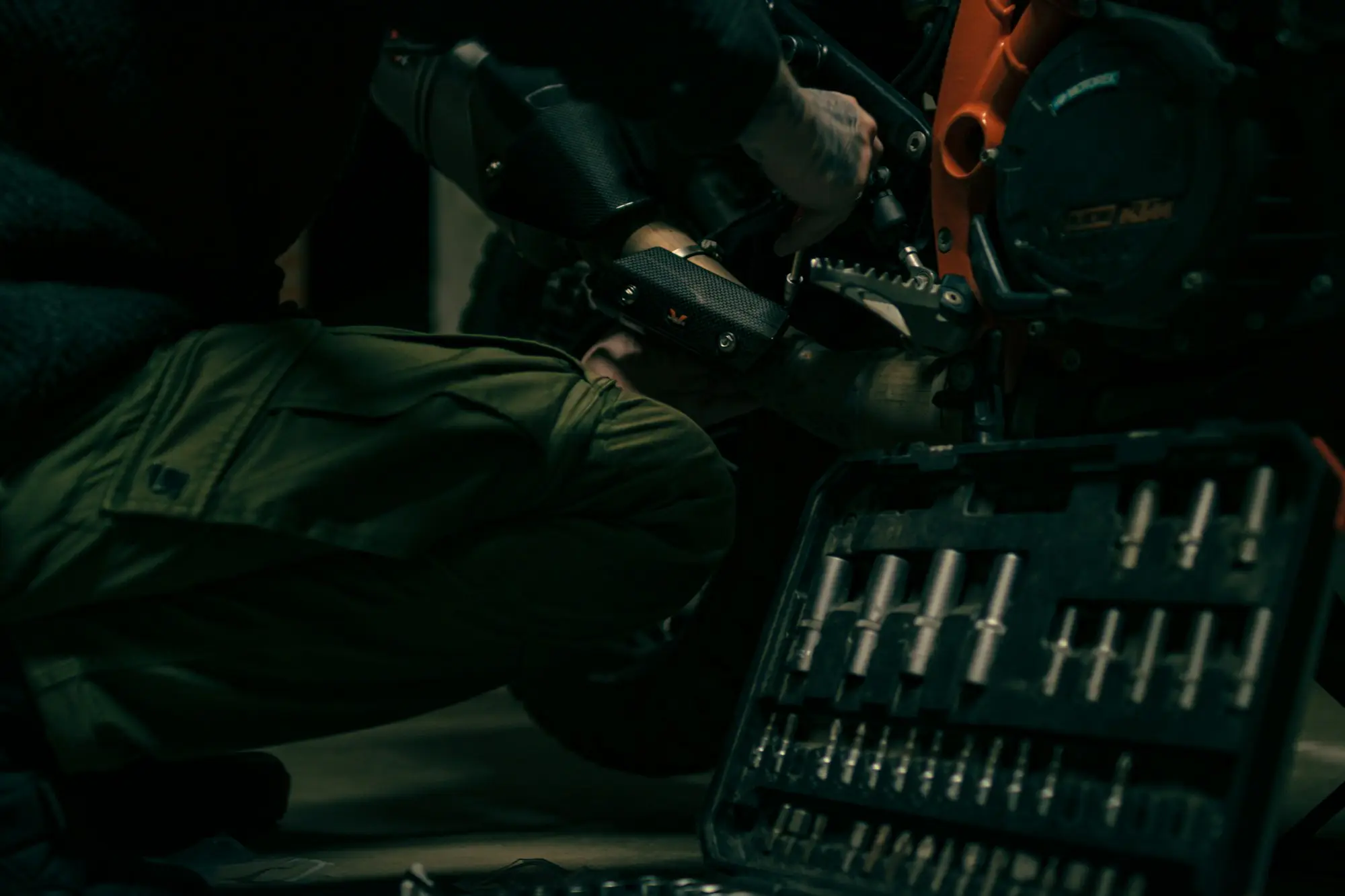 Mechanic working on a motorcycle in a small garage