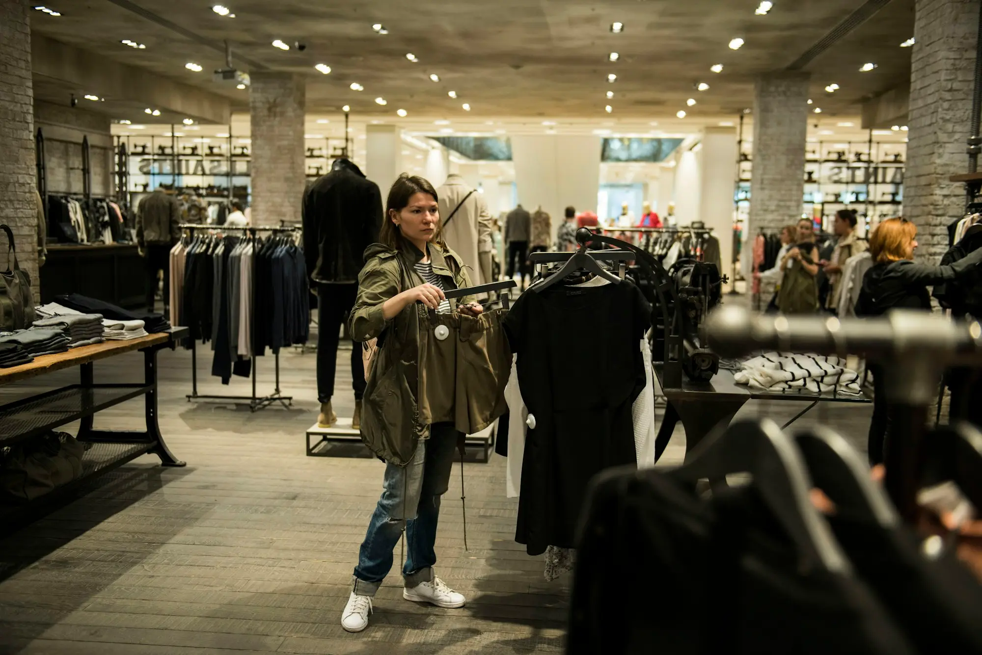 Shop owner holding a garment inside a small clothing store