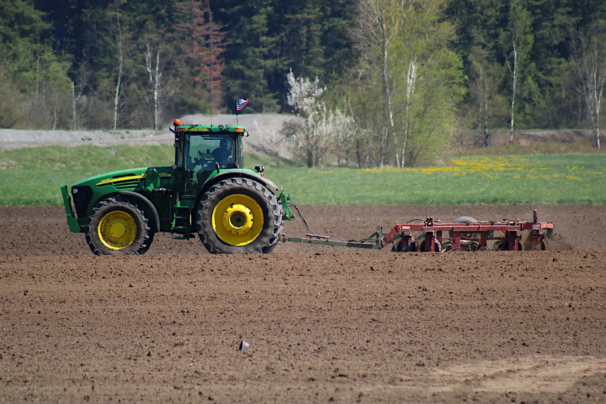 Tractor pulling a plough across a field