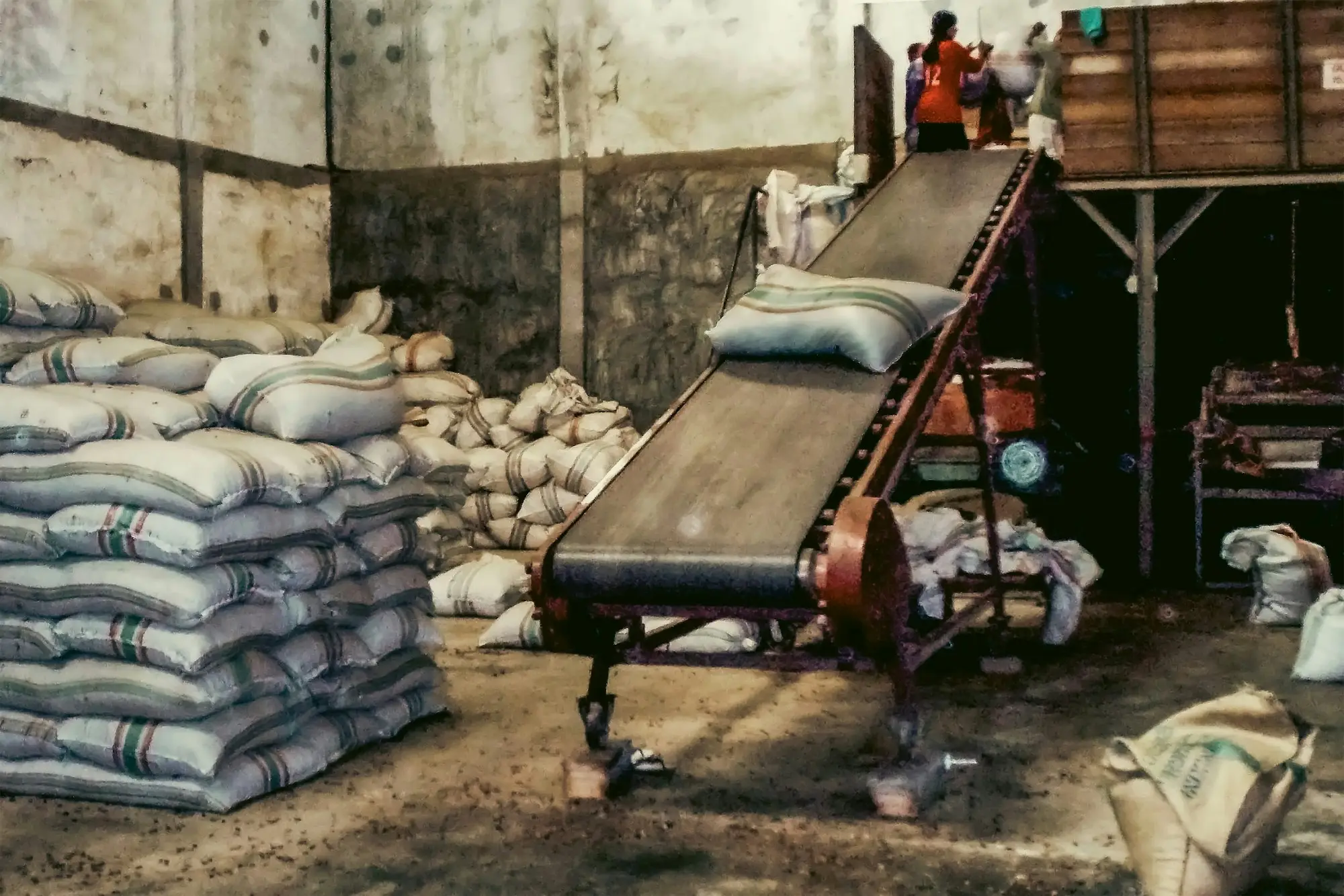 Conveyor belt in a busy warehouse moving bagged stock